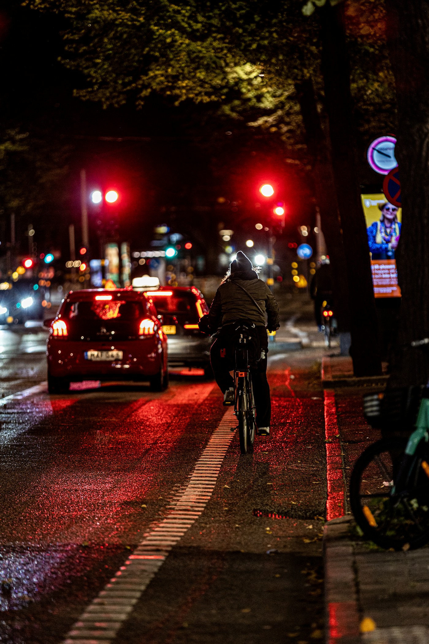 City cyclist switching on front and rear bicycle lights at dusk